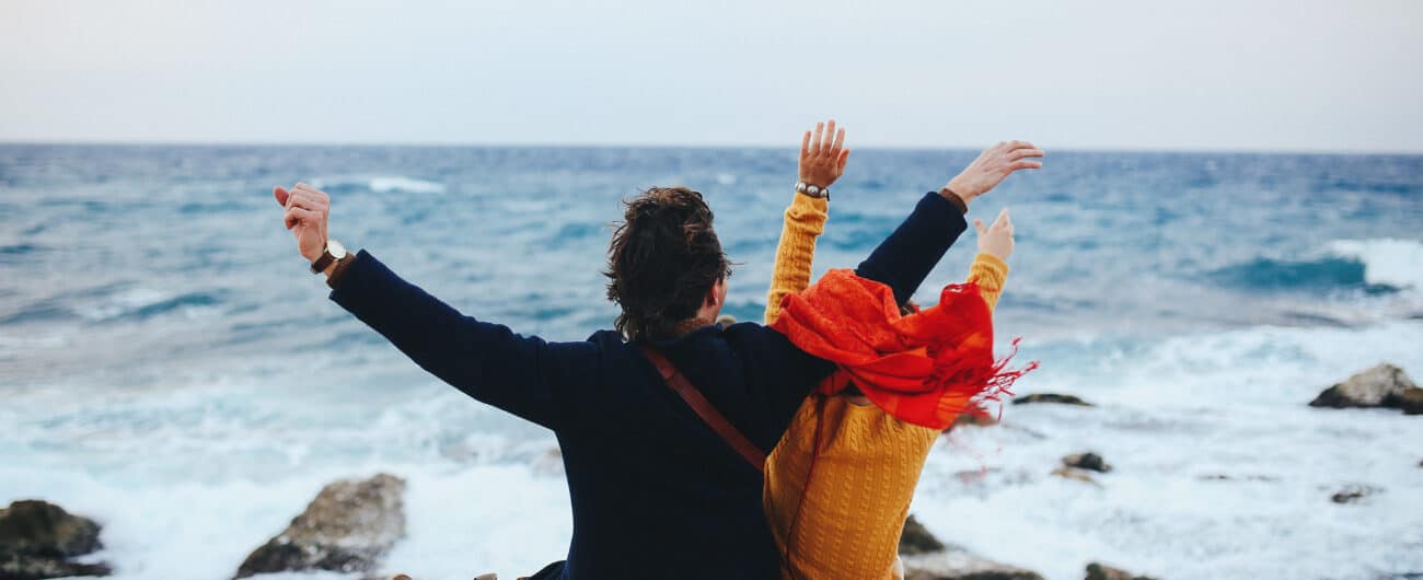 Couple in love sits on the quay, and looks at the sea, they feel