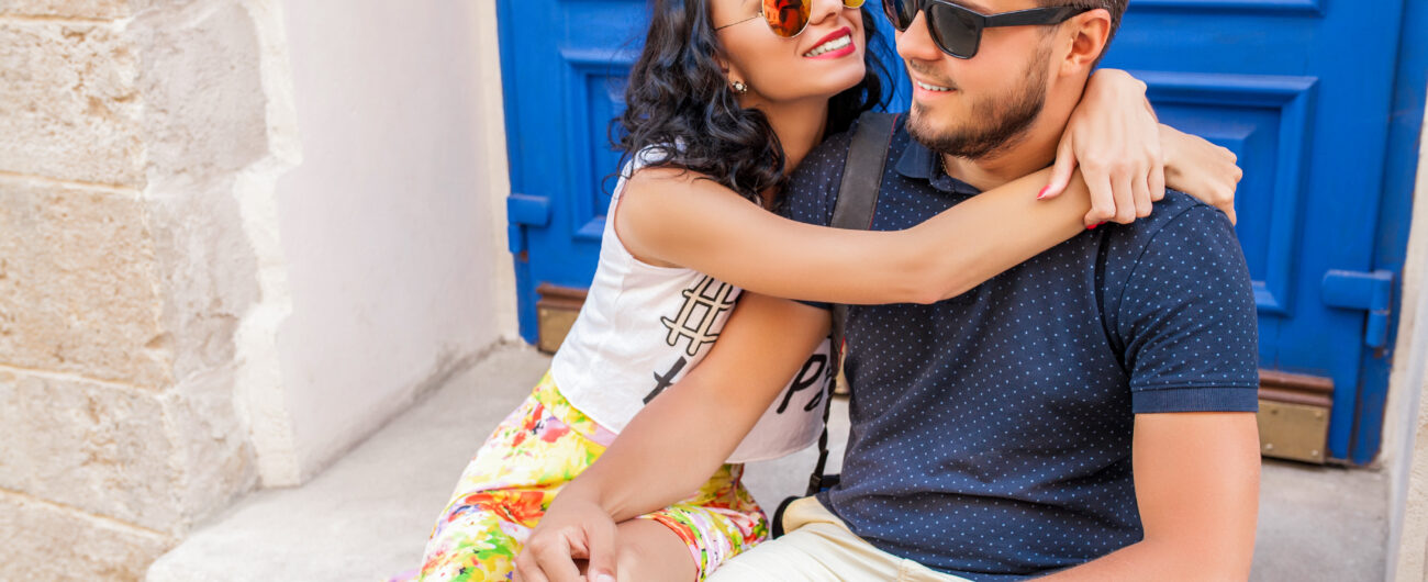 cool young beautiful hipster couple in love sitting on old city street, summer Europe vacation, travel, fun, happy, smiling