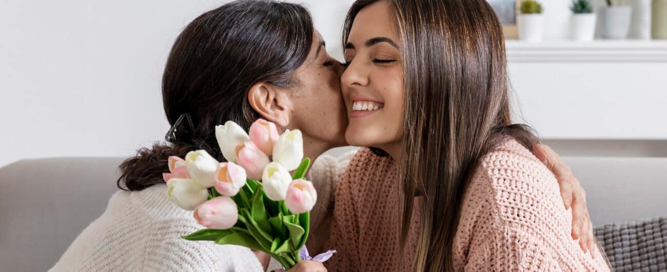 mother-kissing-girl-flowers_23-2148482926